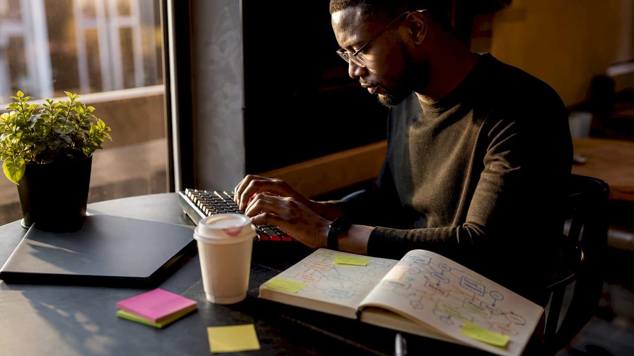 Developer hands sketching AI MVP steps on notebook