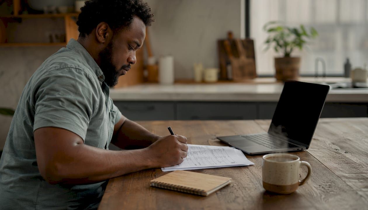 Hands writing notes on security checklist document