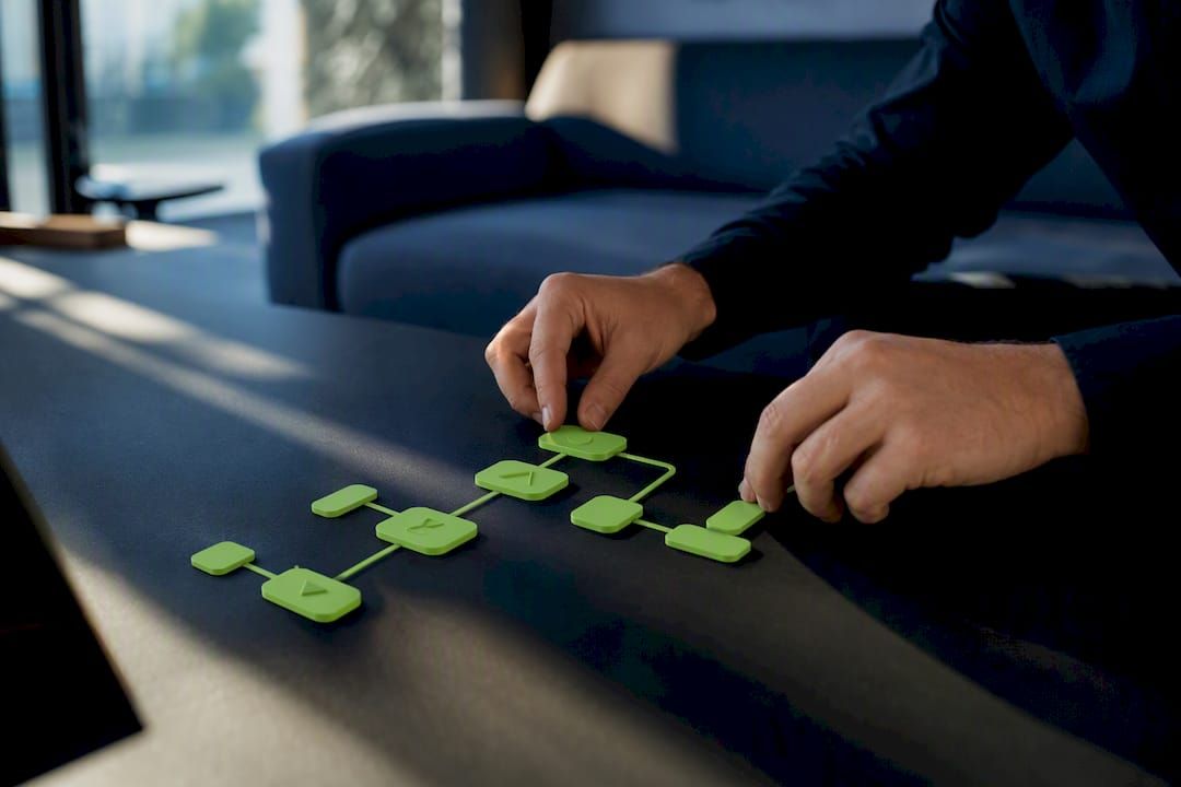 Hands routing modular tokens representing automation